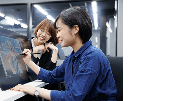 液晶タブレットでイラストを描く学生