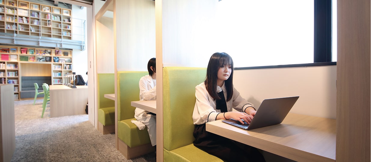 図書館の半個室ブースでパソコンを触る学生