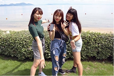 浜辺で記念撮影をする学生たち