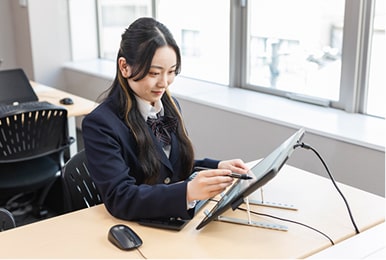 液晶タブレットに書き込む学生